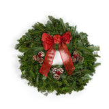 Large fresh green Christmas wreath with a variety of Christmas tree clippings. This has a small red bow, and 3 sets of 3 pinecones arranged with berries in the center of each pinecone set near the center of the wreath.