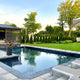 Emerald Green Arborvitae lining a backyard pool area with a well-manicured lawn.
